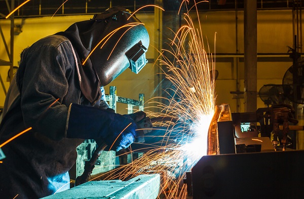 Worker, welding in a car factory with sparks, manufacturing, ind